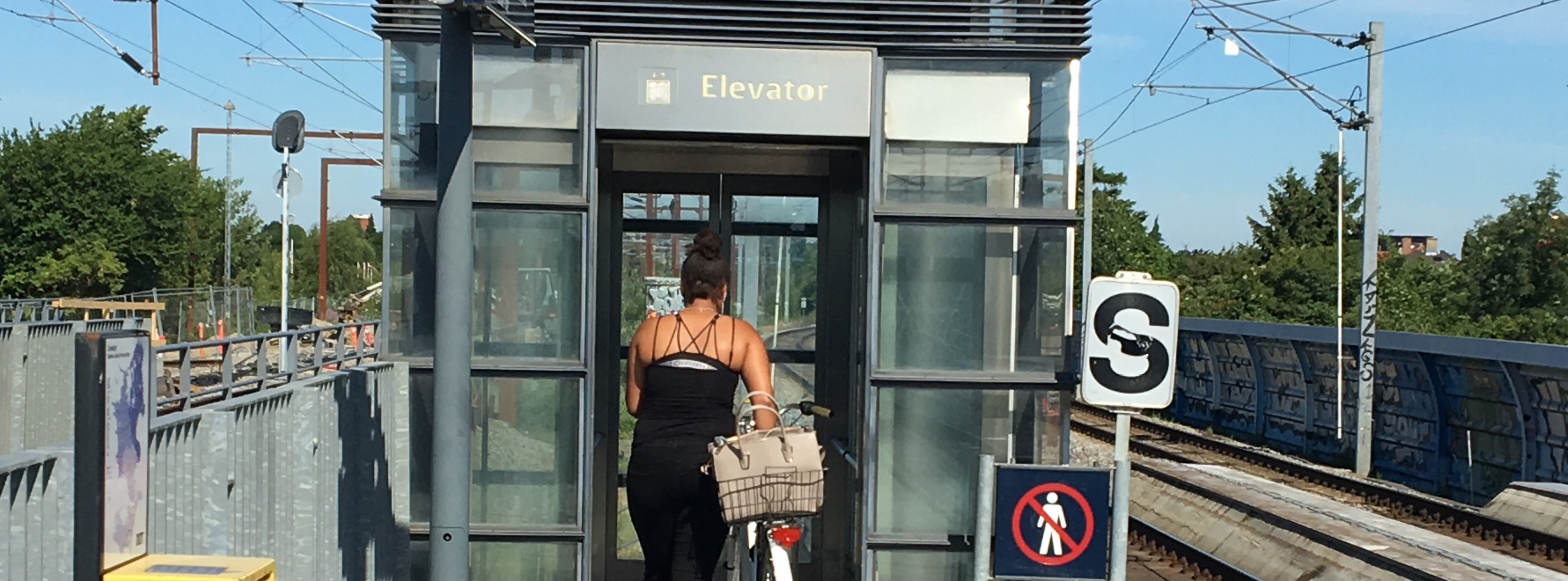 Kvinde går ind i elevator på jernbanestation